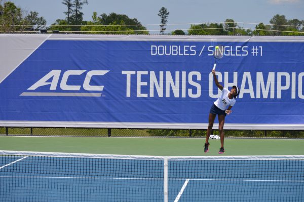 Woman playing tennis in front of a banner that says ACC Tennis Championship