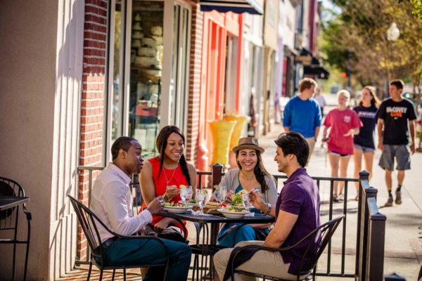 People eat outdoors on a small city street