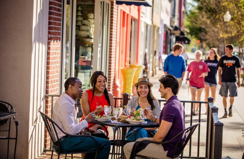 People eat outdoors on a small city street